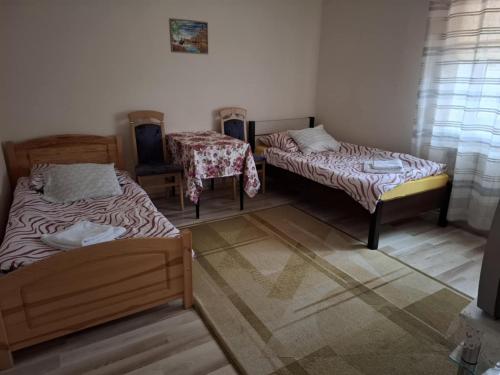a room with two beds and a table at Pokoje Goscinne Buzuki in Ciechanów