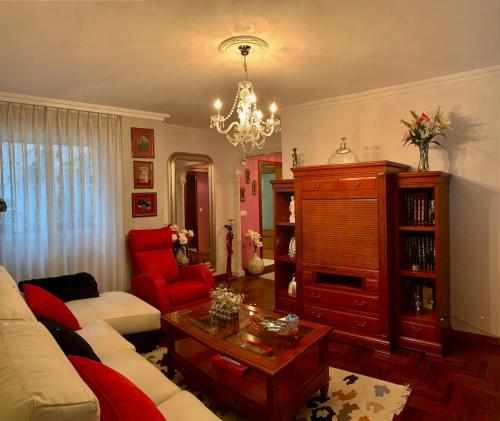 ein Wohnzimmer mit einer Couch und einem Kronleuchter in der Unterkunft Apartamento en Oviedo in Oviedo