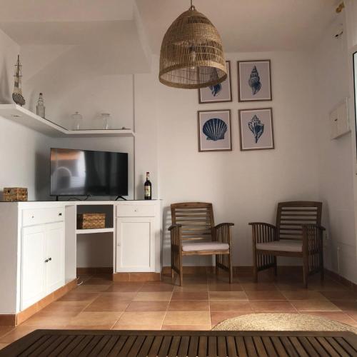 a living room with two chairs and a flat screen tv at casa en Islantilla in Isla Cristina