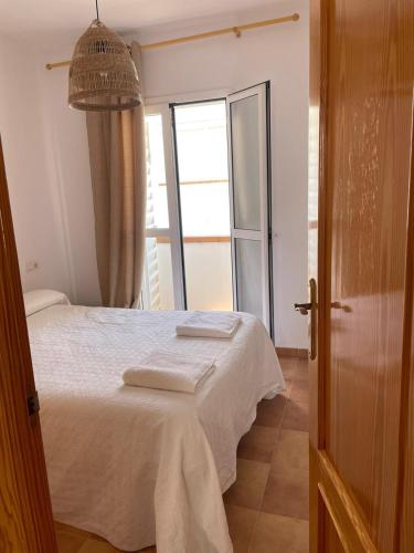 a bedroom with a bed and a large window at casa en Islantilla in Isla Cristina