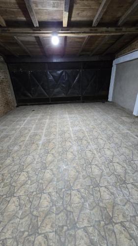 an empty garage with a stone floor and black doors at La Reina in Eldorado