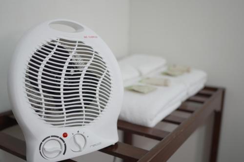 a white fan sitting next to a bed at Colca Canyon Hotel by PERU HTL in Chivay