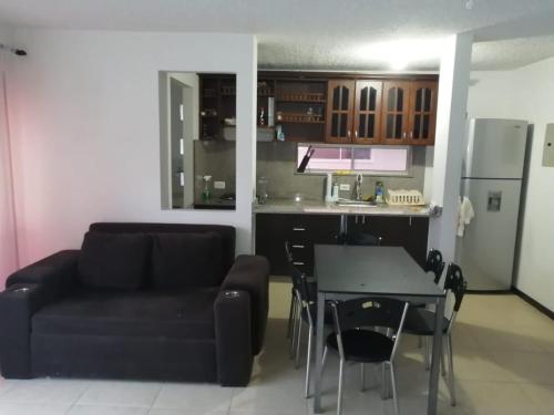 een woonkamer met een bank en een tafel en een keuken bij Apartasol Familiar 2 in Santa Fe de Antioquia
