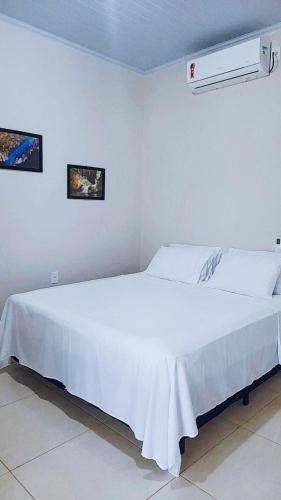 a bedroom with a large white bed in a room at Pousada Diadorim Terra Ronca in Sao Domingos de Goias