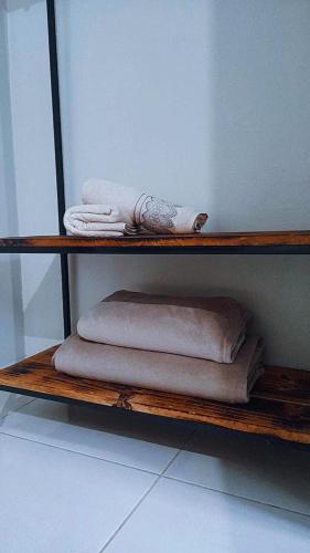 a shelf with three folded towels on it at Pousada Diadorim Terra Ronca in Sao Domingos de Goias