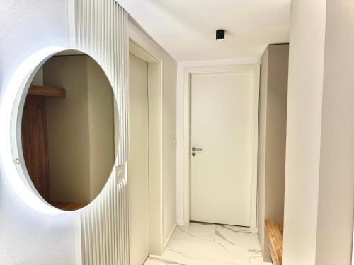 a hallway with a round mirror on a wall at 4FriendsBrasov K1256 in Braşov