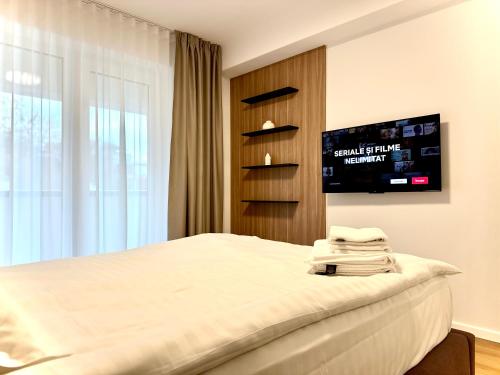 a bedroom with a bed and a flat screen tv at 4FriendsBrasov K1256 in Braşov