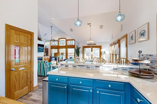 a kitchen with blue cabinets and a counter top at Play Time in Waves