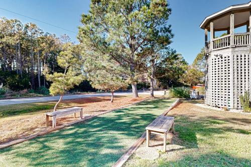 two benches sitting in the grass in a park at Play Time in Waves