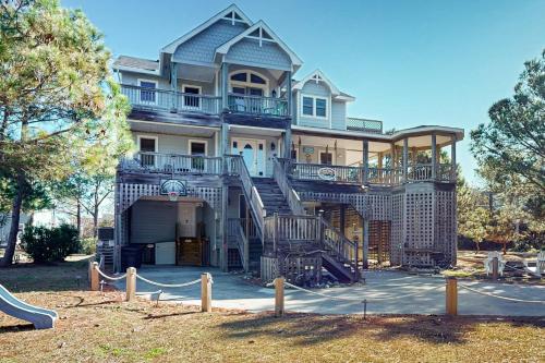 a large house with a staircase in front of it at Play Time in Waves