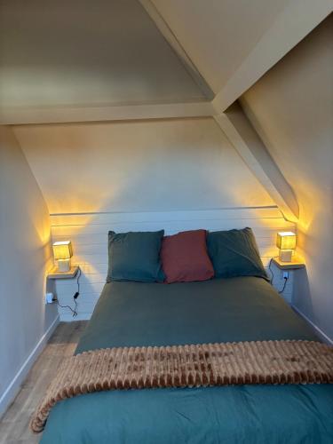 a bed in a room with two lamps on both sides at Appartement des Capucins in Cambrai