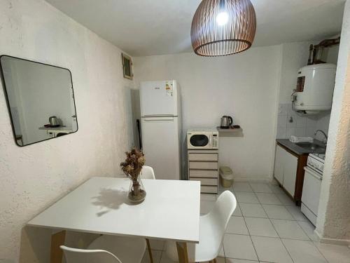 a kitchen with a white table and a white refrigerator at Departamento en Nueva Córdoba in Cordoba