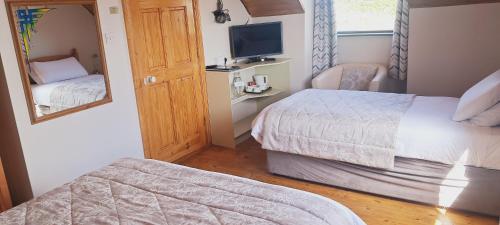 a hotel room with two beds and a mirror at Melrose Bed and Breakfast in Clonakilty