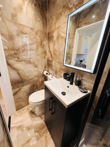 a bathroom with a sink and a toilet and a mirror at R4 - Elegant Private Room with Kitchenette near QE Hospital Harborne in Birmingham