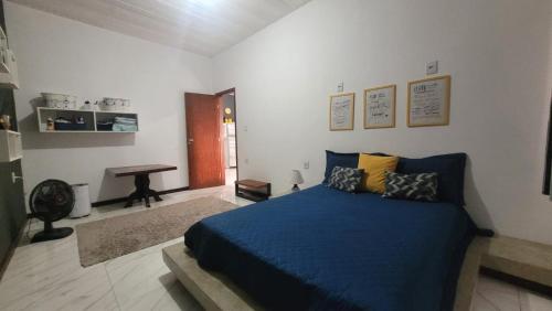 Schlafzimmer mit einem blauen Bett und einem Schreibtisch in der Unterkunft Casa de Praia na Roça in Angra dos Reis