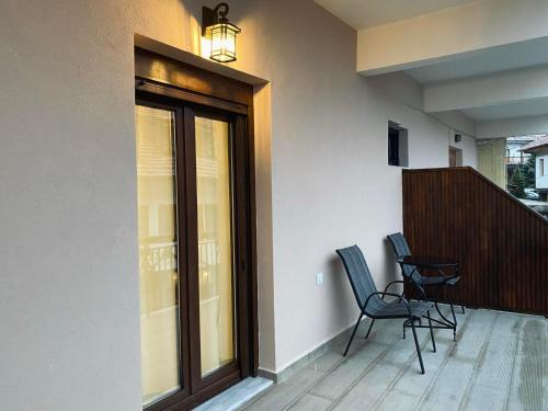 two chairs sitting on the balcony of a house at Abete Luxury Apartments in Metsovo