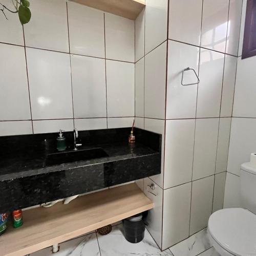 a bathroom with a sink and a toilet at Casa do vivi 1 in Tramandaí
