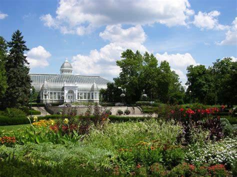 a large white building with a garden with flowers at Cozy 3BR Condo near OSU Perfect for Students, Workers & Staycations in Columbus