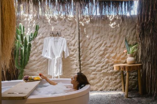 une femme assise dans une baignoire avec une robe blanche dedans dans l'établissement Pousada Villa Cacau, à Trancoso