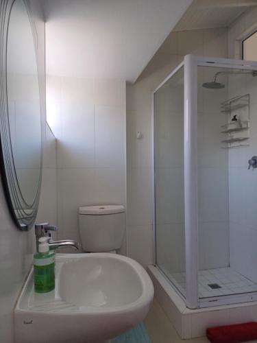 a white bathroom with a shower and a sink at Chuu's Cosy Place in East London