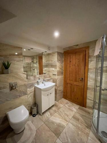 a bathroom with a toilet and a sink and a shower at Chata Margitka in Dúbrava