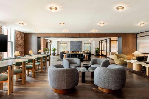 a lobby with chairs and tables and a bar at Arlo Washington DC in Washington