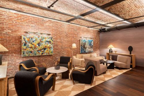 a lobby with chairs and tables and a brick wall at Arlo Washington DC in Washington