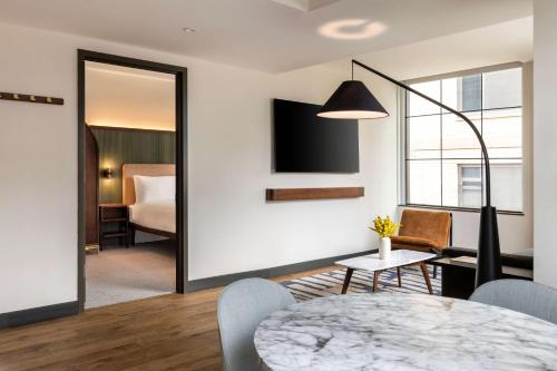 a living room with a table and a bedroom at Arlo Washington DC in Washington