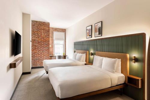 a hotel room with two beds and a television at Arlo Washington DC in Washington