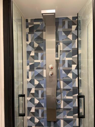 La salle de bains est pourvue d'une douche et d'un mur en mosaïque. dans l'établissement La Grande Suite Duplex- rue Vasselot - Calme - Standing five, à Rennes