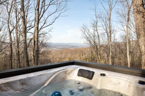 una vasca idromassaggio con vista sul bosco di Hygge mountain retreat with stunning views a New Market