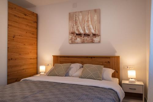 a bedroom with a large bed with two lamps at Apartment ILUX-2 in Novigrad Dalmatia