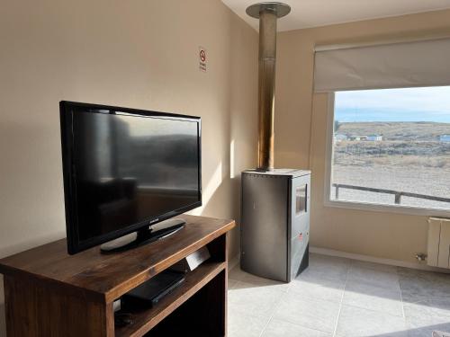 a flat screen tv sitting on top of a wooden entertainment center at Posada Ruta 40 in Monte Dinero