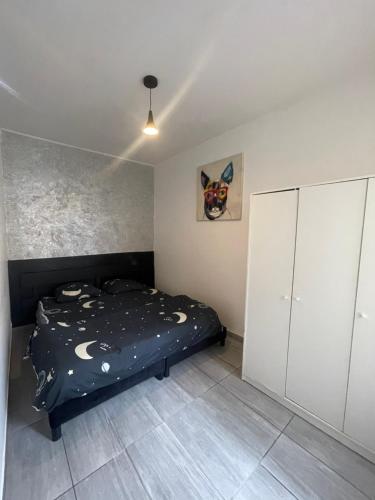 a bedroom with a bed and a white cabinet at Maison agréable Villeneuve saint Georges in Villeneuve-Saint-Georges