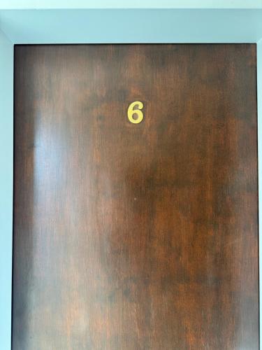 a wooden door with the number six on it at Posada Ruta 40 in Monte Dinero