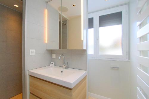 a bathroom with a sink and a mirror and a window at Le 24 in Les Deux Alpes