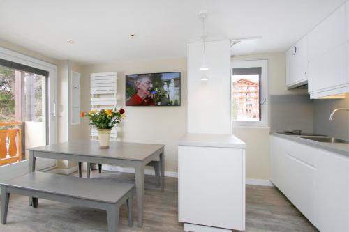 une cuisine avec une table et une table sidx sidx sidx dans l'établissement Le 24, à Les Deux Alpes