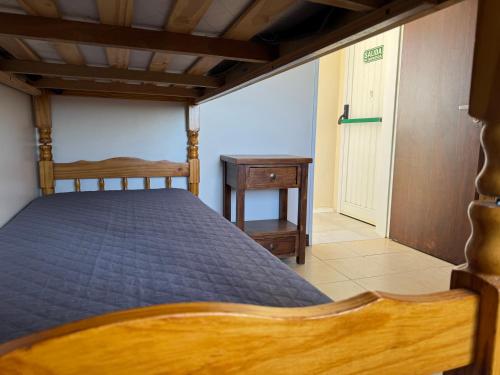 a bedroom with a bed and a table and a door at Posada Ruta 40 in Monte Dinero