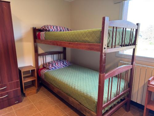 two bunk beds in a room with a window at Posada Ruta 40 in Monte Dinero