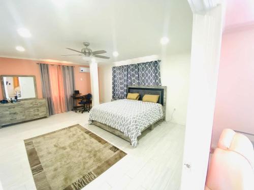 a bedroom with a bed and a ceiling fan at Celebrity Suite - 3 Bedroom in Beterverwagting