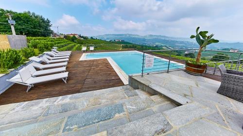 a swimming pool with lounge chairs next to at Casa Sobrero in Castiglione Falletto