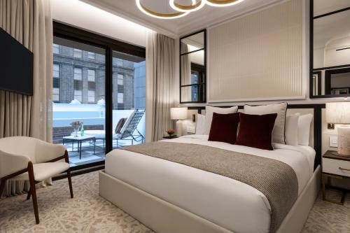 a bedroom with a large bed and a balcony at The Chemists Club Hotel in New York