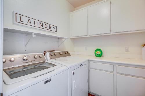 a white kitchen with a washer and dryer at 1 Mi to Coachella Indio Home with Community Perks! in Indio