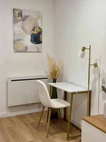 Cette chambre blanche dispose d'un bureau et d'une chaise. dans l'établissement Au Golden Duplex - Centre - Clim - Parking, à Narbonne