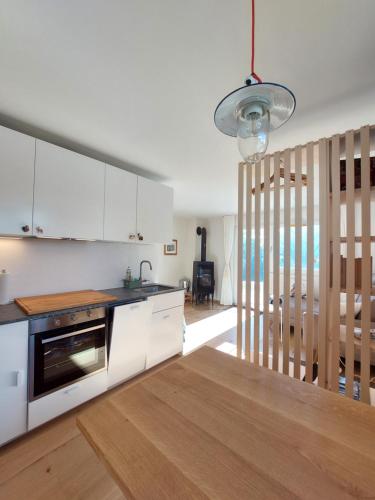 a kitchen with white cabinets and a stainless steel appliance at Ferienwohnung CAMANABODA in Camanaboda