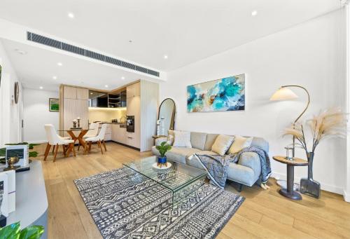 a living room with a couch and a table at Urban Bliss 2BR Abode - Luxury丨Comfort丨Parking in Sydney
