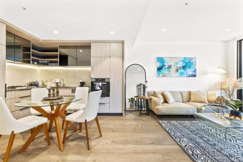 a kitchen and living room with a table and chairs at Urban Bliss 2BR Abode - Luxury丨Comfort丨Parking in Sydney