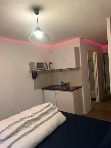 a room with a kitchen with a table and a microwave at Studio fonctionnel App 16 Centre ville Paray in Paray-le-Monial