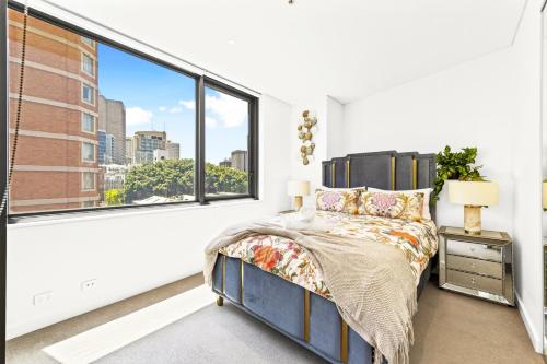 a bedroom with a bed and a large window at Urban Bliss 2BR Abode - Luxury丨Comfort丨Parking in Sydney