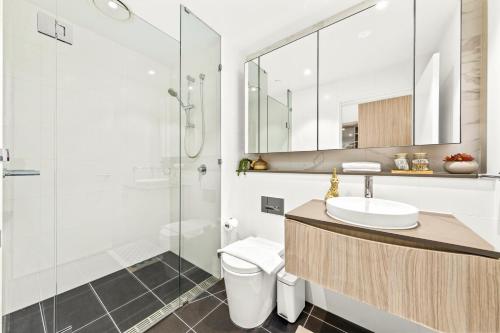 a bathroom with a toilet and a sink and a shower at Urban Bliss 2BR Abode - Luxury丨Comfort丨Parking in Sydney